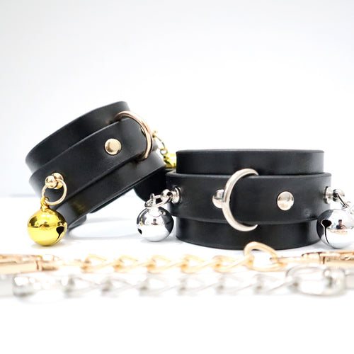 Gold-tone and silver-tone hardware options on black PU bell wrist cuffs
