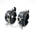 Black PU wrist cuffs with silver-tone bells and detachable chain